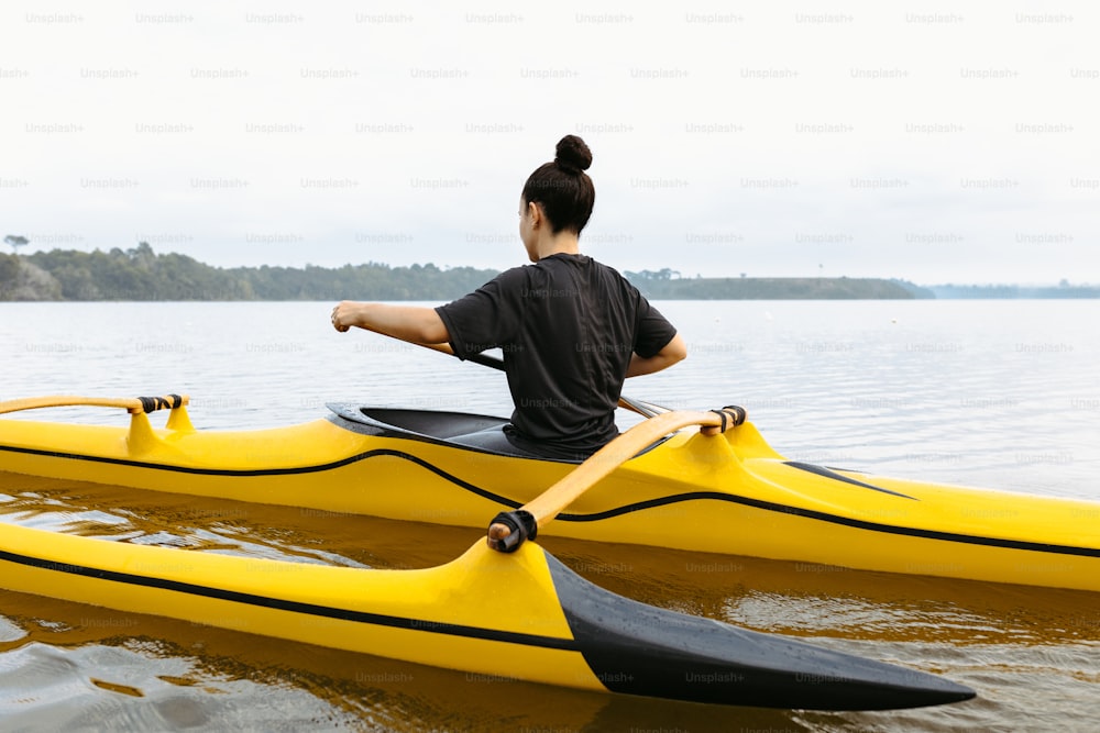 una donna seduta su un kayak giallo nell'acqua