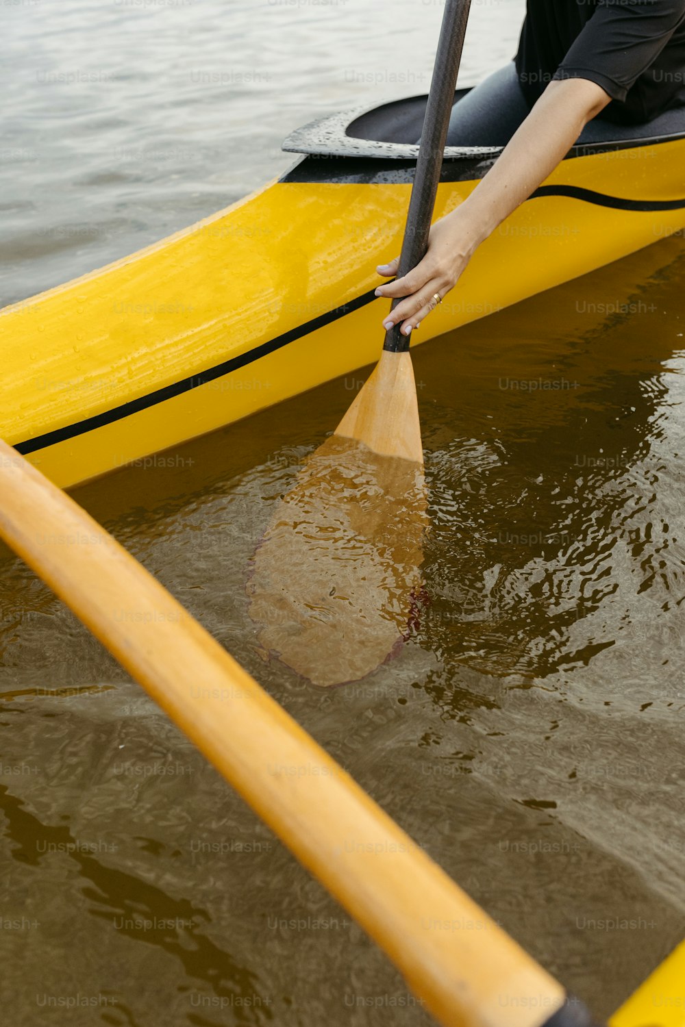 a person in a yellow kayak with a paddle