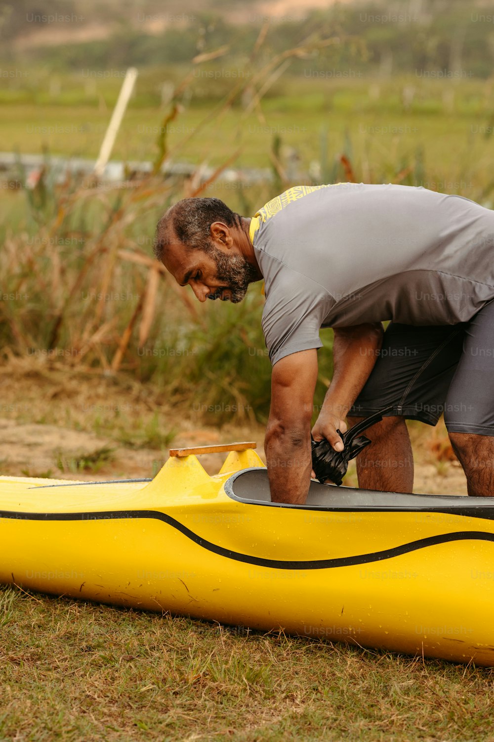 Un hombre trabajando en un kayak en el suelo