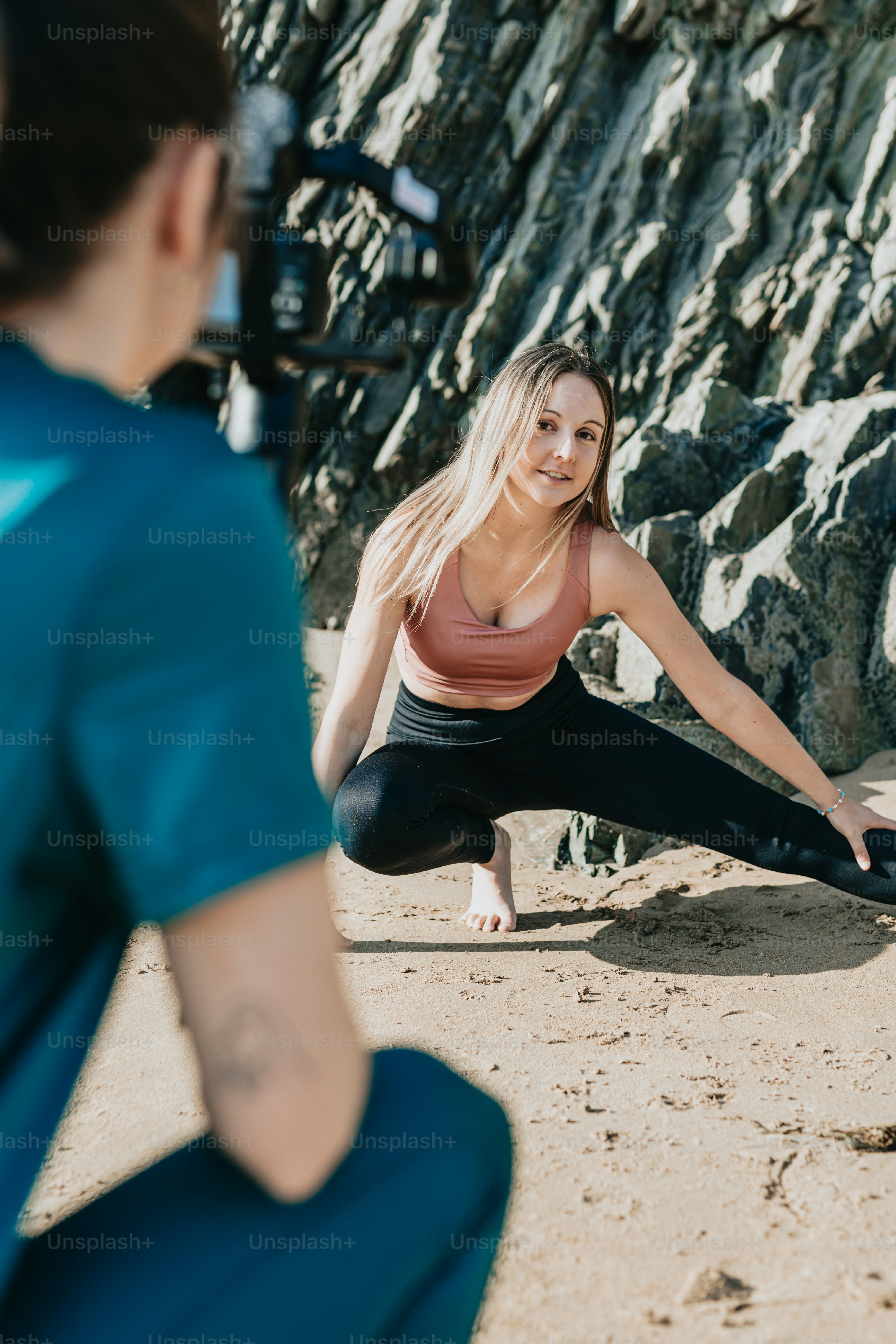a woman is doing yoga on the beach