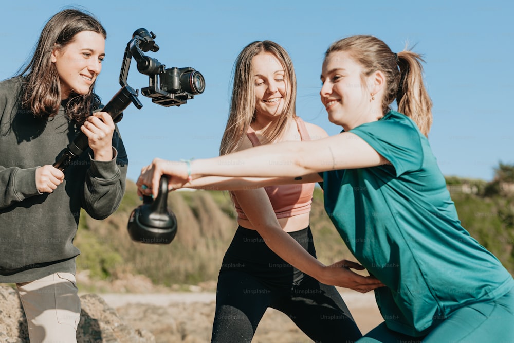 a group of women holding a camera and a tripod