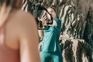 a woman taking a picture of herself in front of a rock