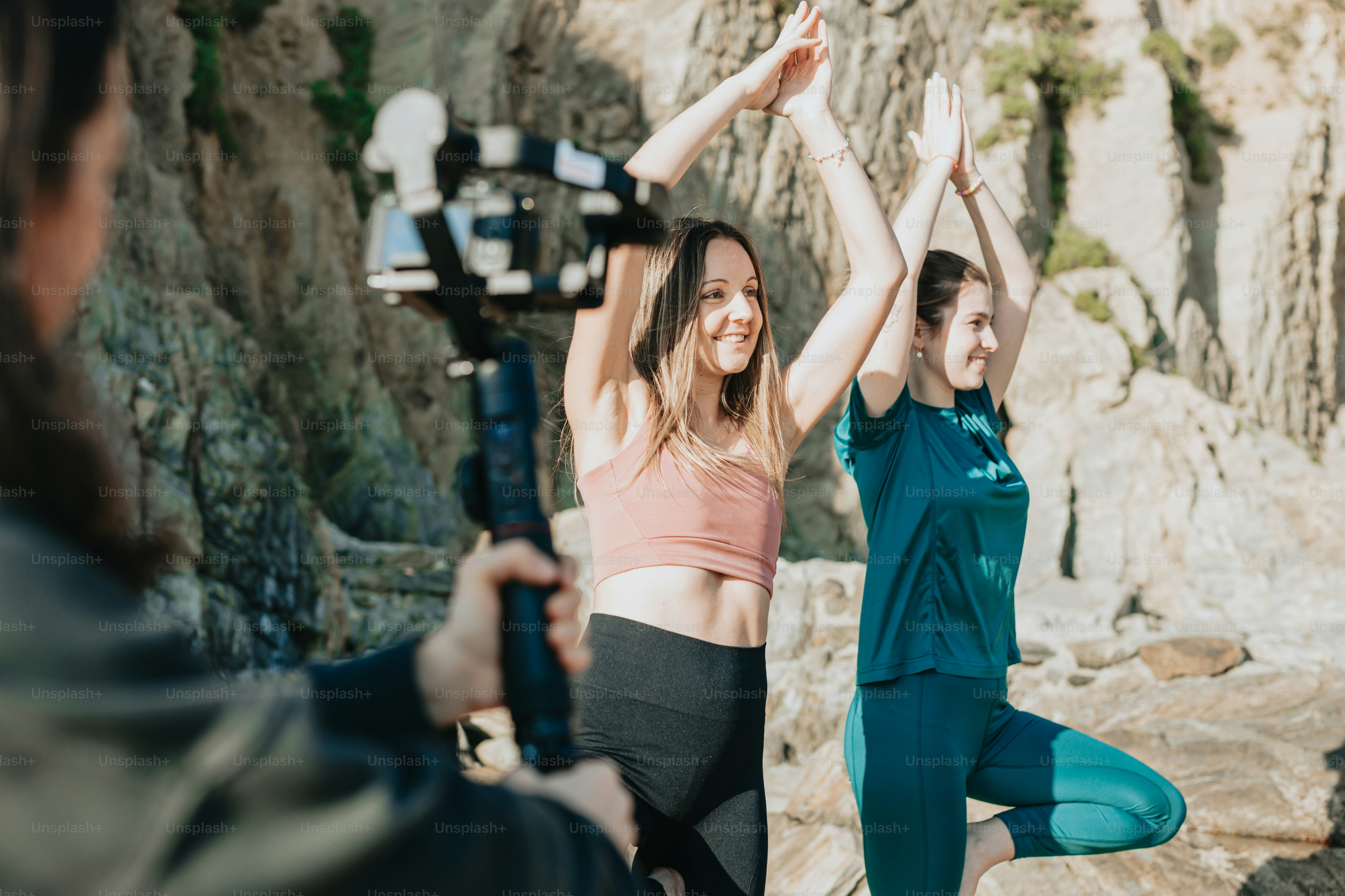 two women doing yoga in front of a mountain