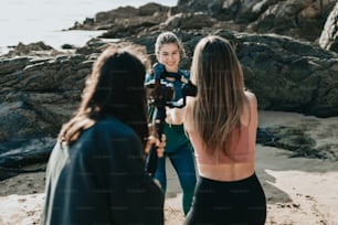 Un groupe de femmes debout au sommet d’une plage de sable