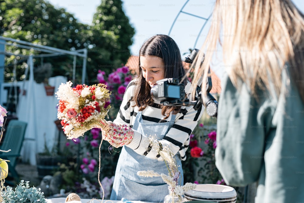 a woman holding a bouquet of flowers in front of a camera
