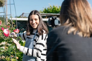 a woman holding a pink flower in her hand