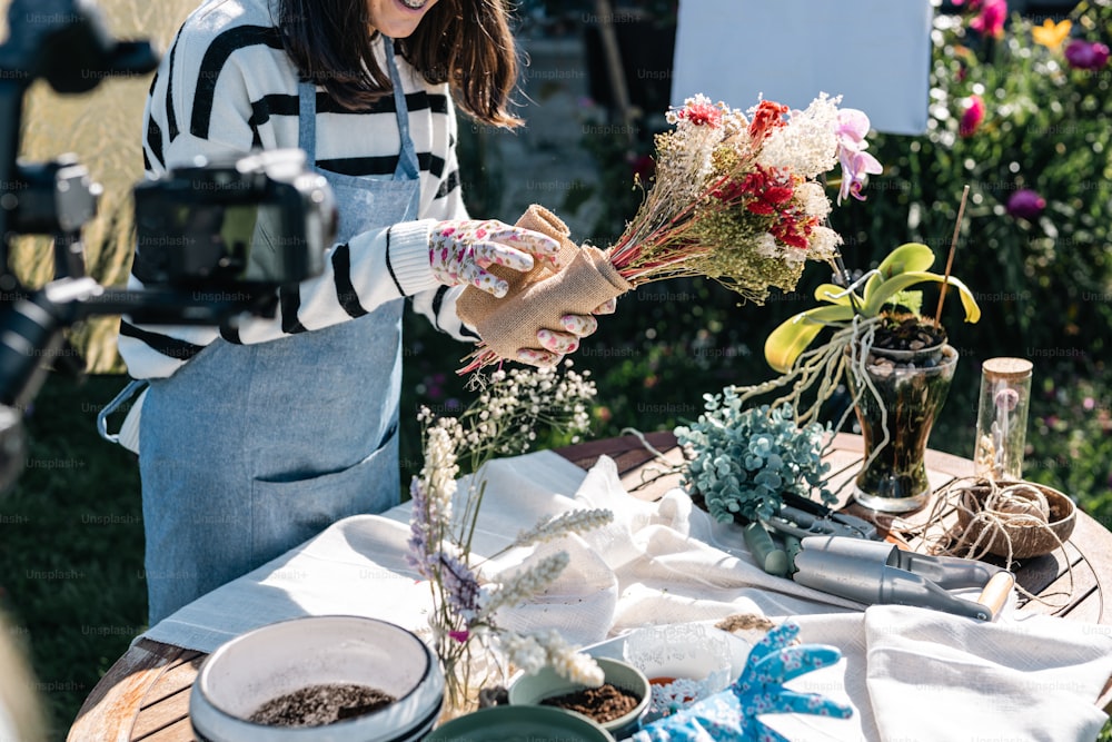 Eine Frau arrangiert Blumen auf einem Tisch