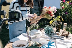 a woman is arranging flowers on a table