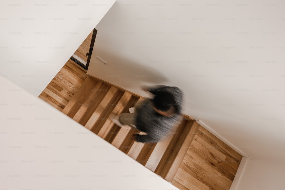 Una foto sfocata di una persona in piedi su un pavimento di legno