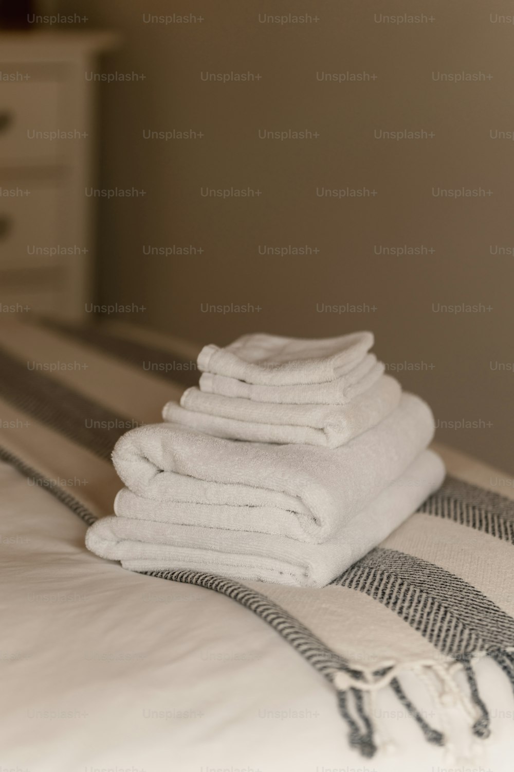 uma pilha de toalhas dobradas sentada em cima de uma cama
