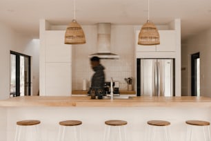 a man standing in a kitchen next to a counter