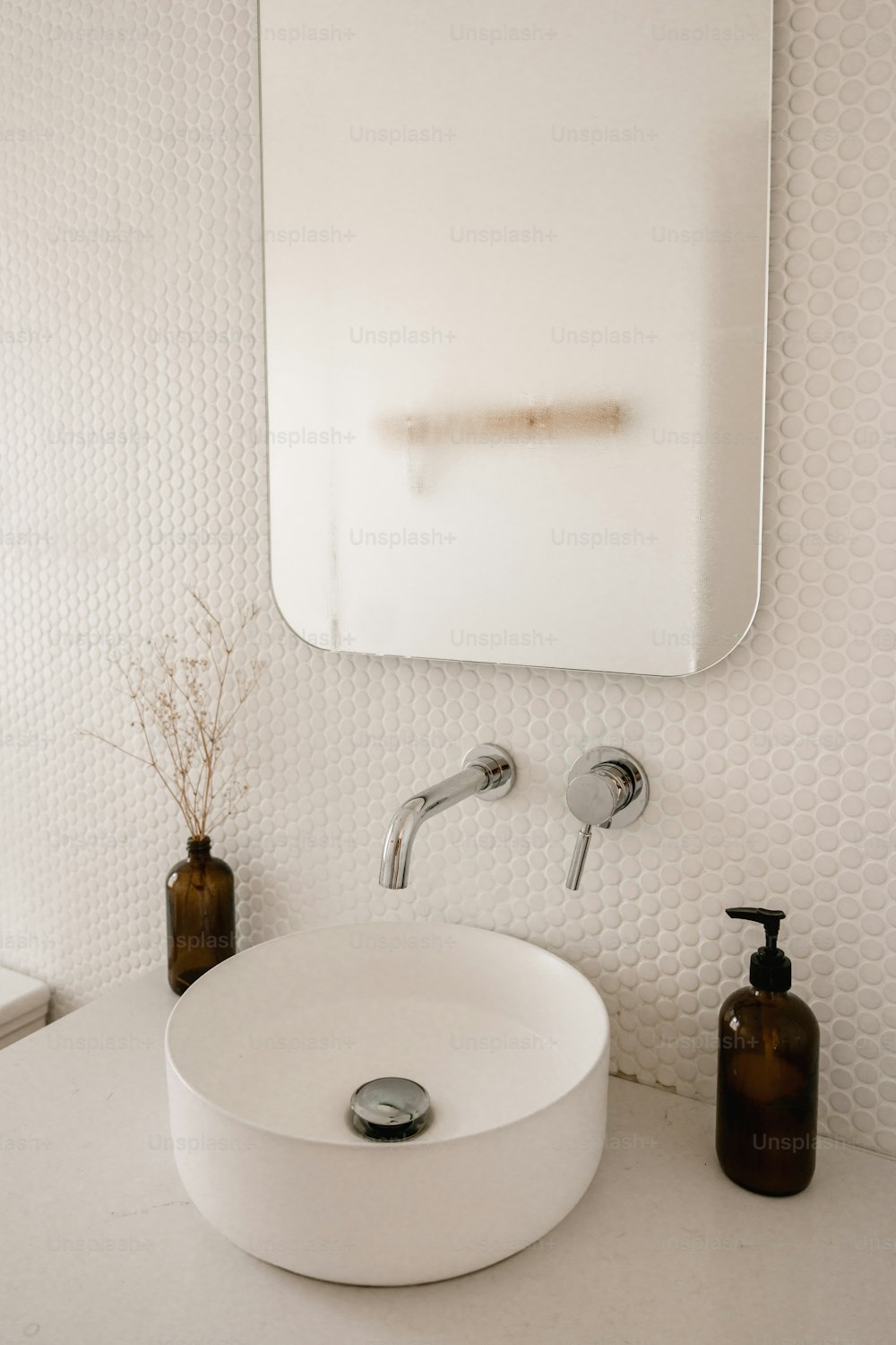 a white sink sitting under a bathroom mirror