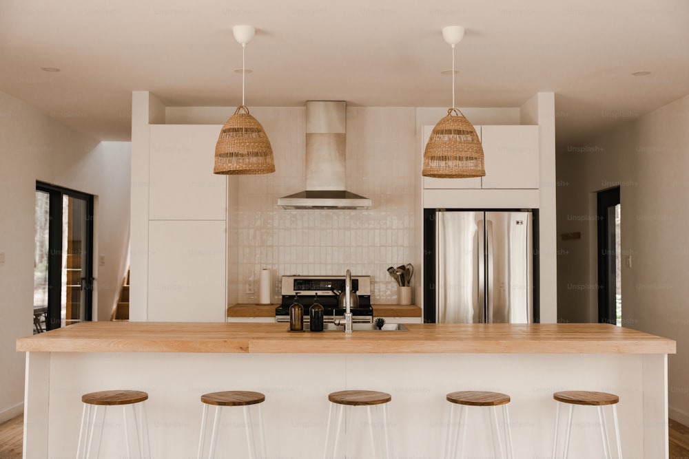 a kitchen with three stools next to a counter