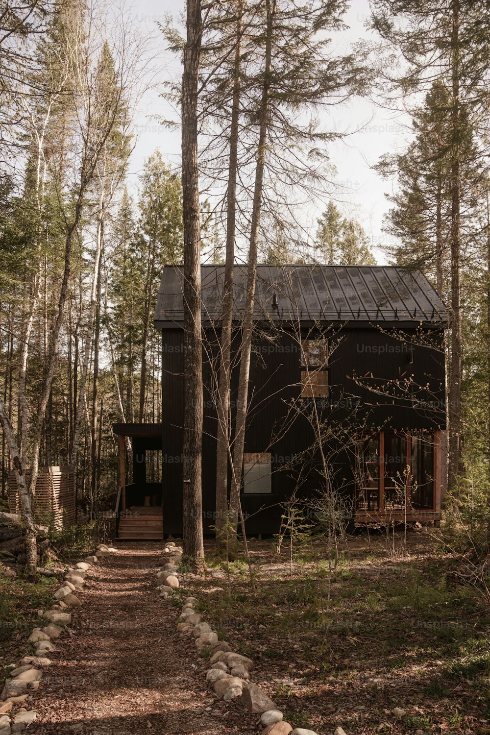 uma casa na floresta com um caminho que leva a ela