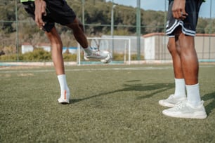 a couple of men standing on top of a soccer field