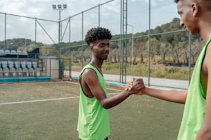 two men shaking hands on a tennis court