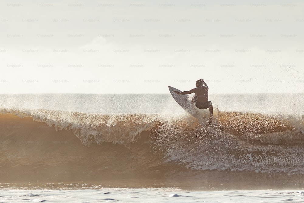 Un uomo che cavalca un'onda in cima a una tavola da surf