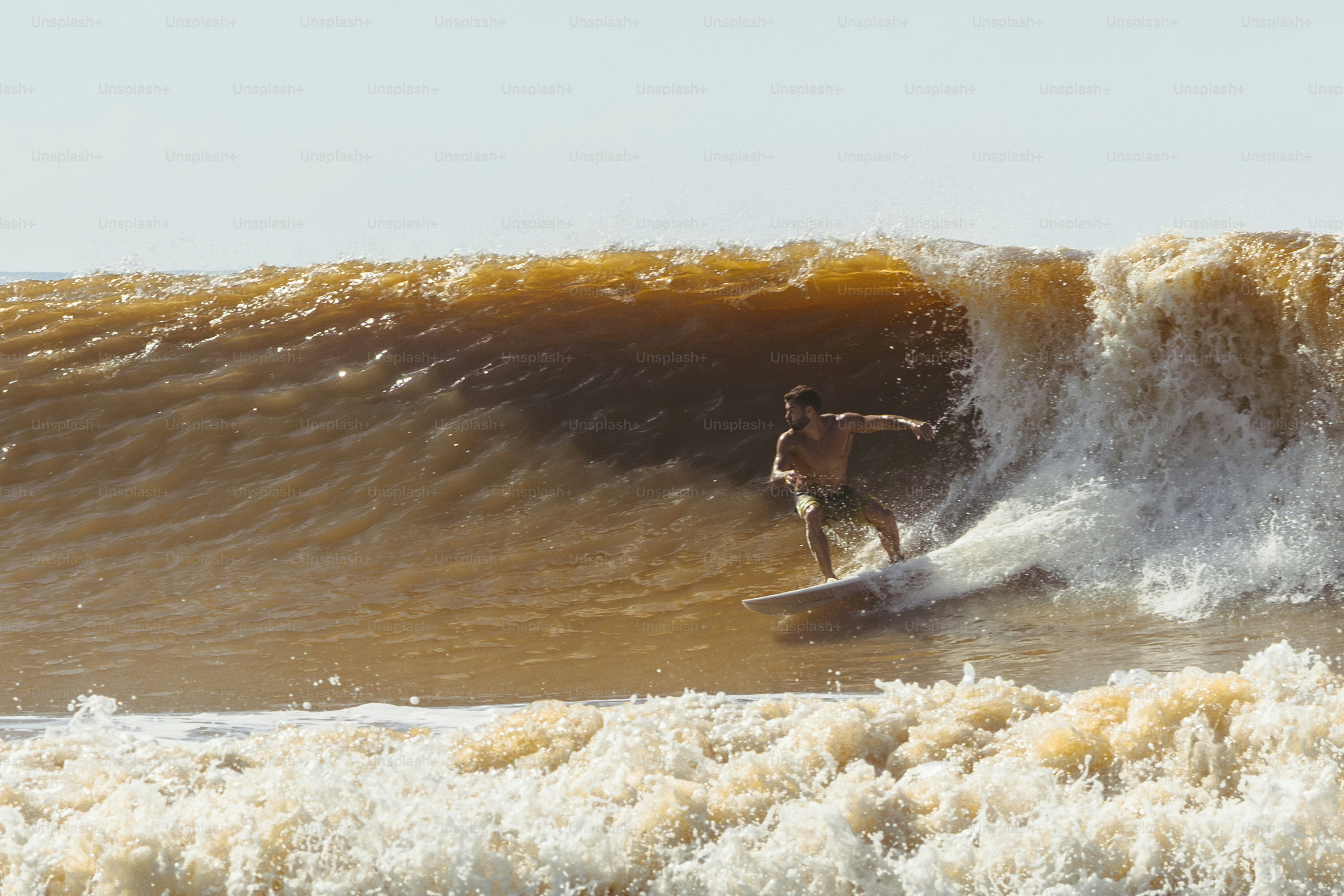 um homem cavalgando uma onda em cima de uma prancha de surf