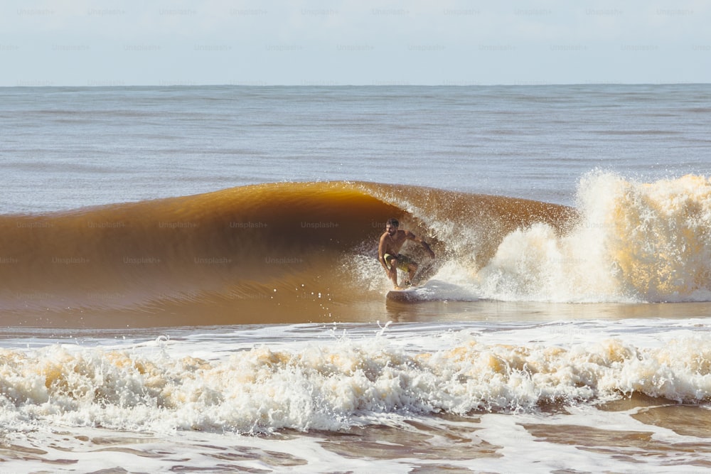 a man riding a wave on top of a surfboard