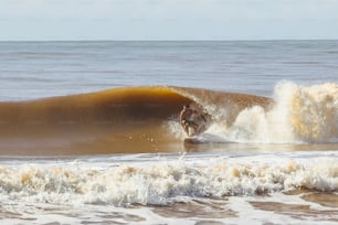 Ein Mann, der auf einem Surfbrett auf einer Welle reitet