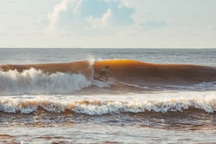 a man riding a wave on top of a surfboard