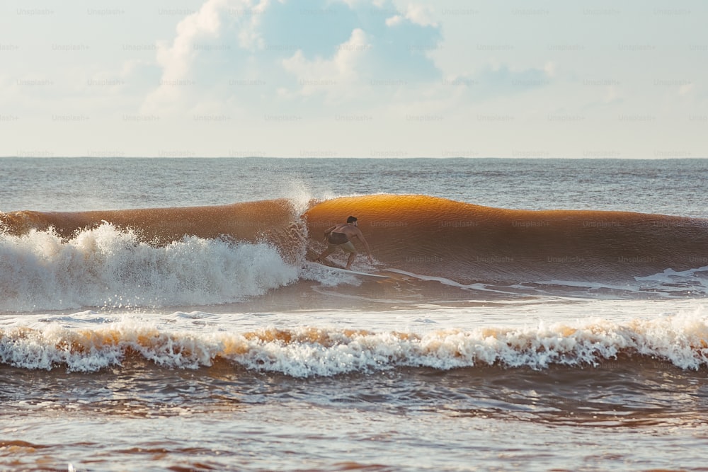 Un uomo che cavalca un'onda in cima a una tavola da surf