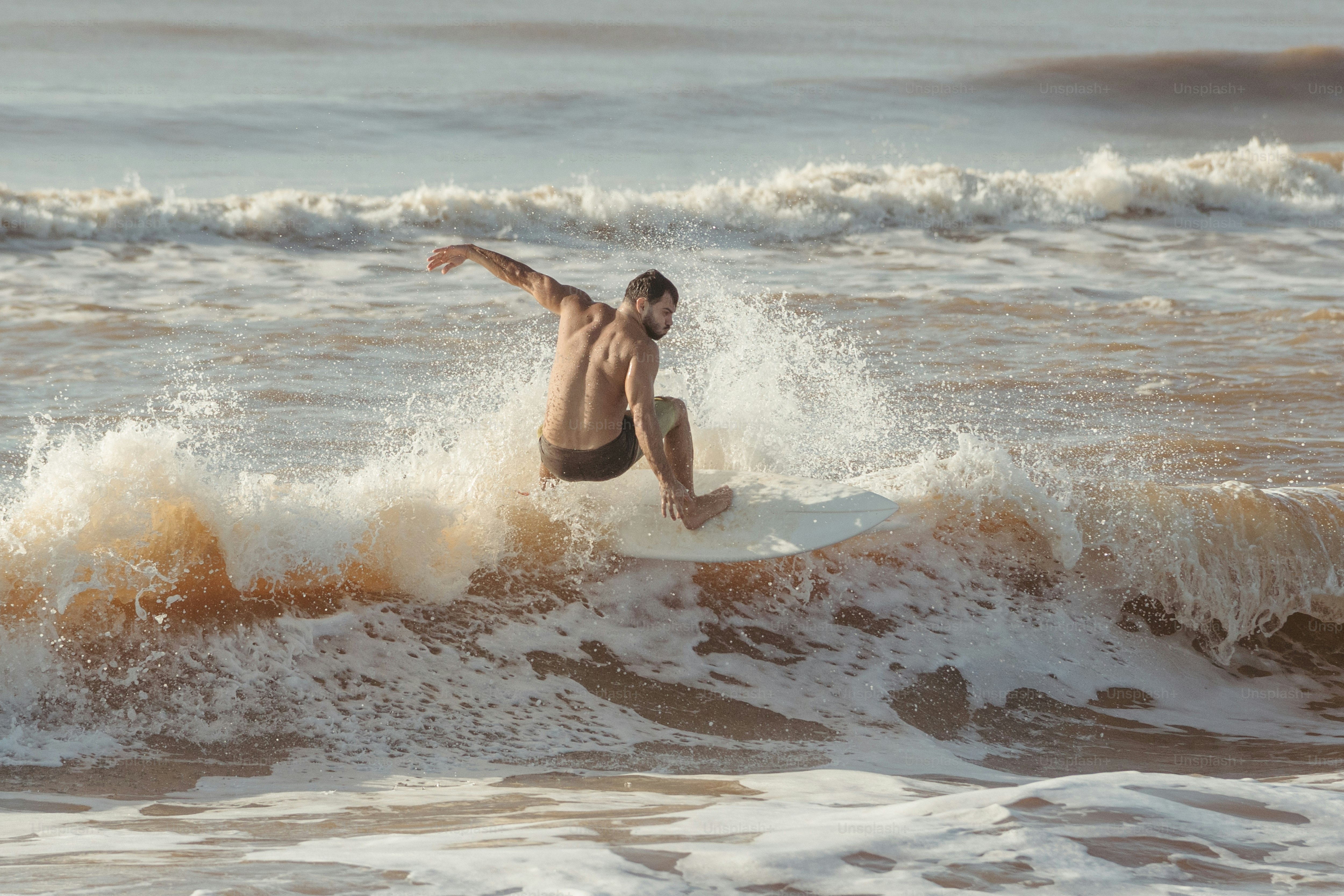 um homem cavalgando uma onda em cima de uma prancha de surf