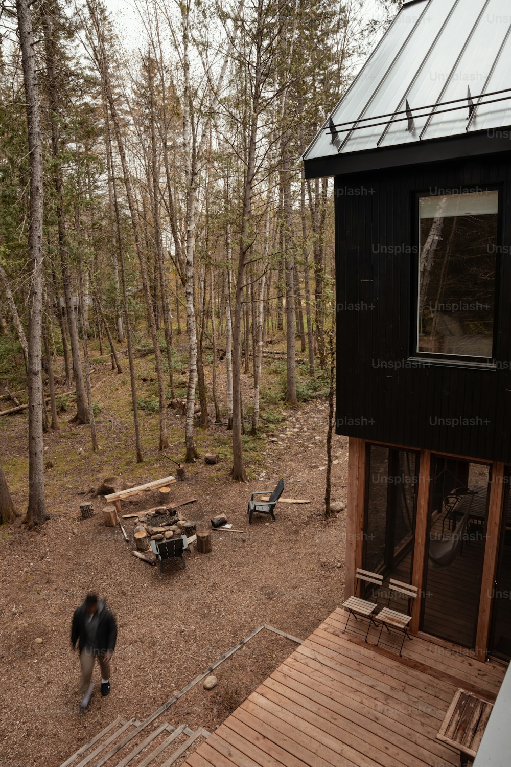 a dog is standing outside of a cabin in the woods