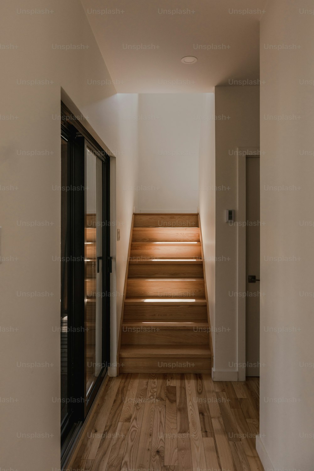 a wooden staircase leading up to a white wall