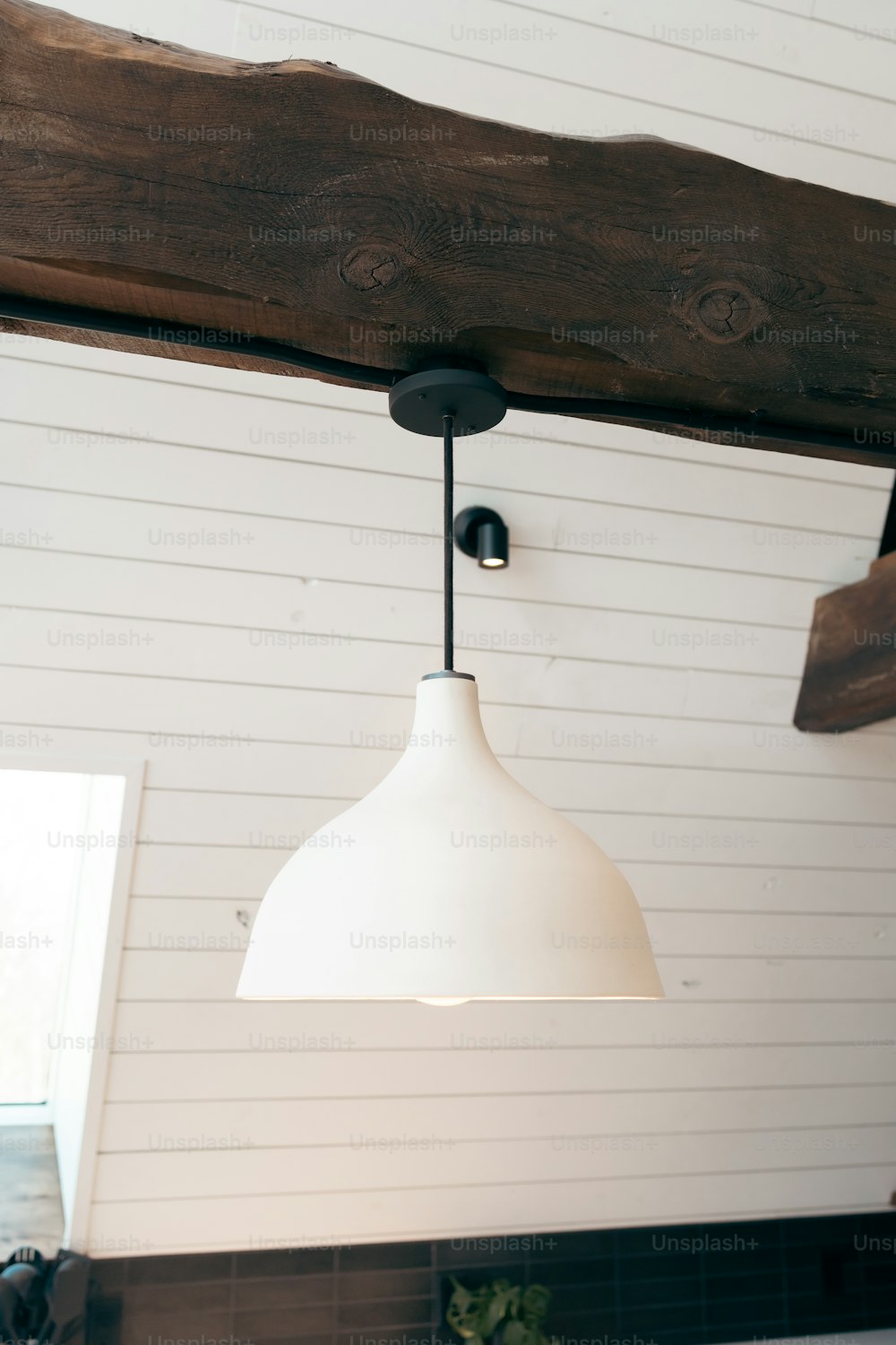 a white light hanging from a wooden beam