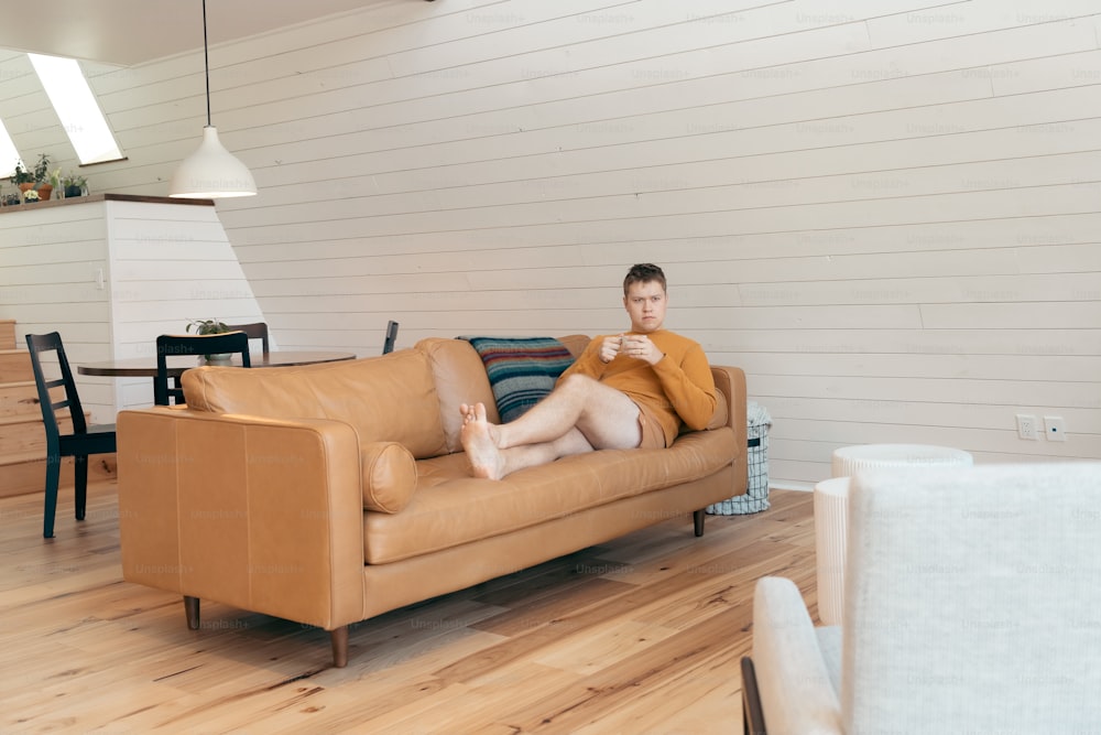 Un hombre sentado en un sofá en una sala de estar