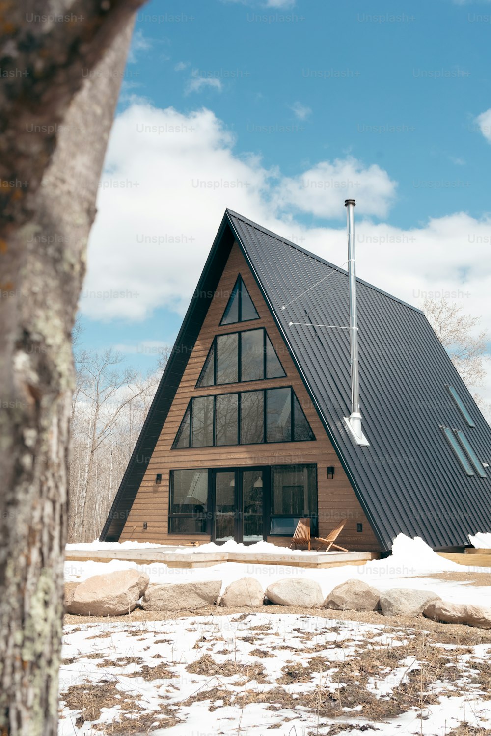 une maison avec un toit métallique et une cheminée métallique