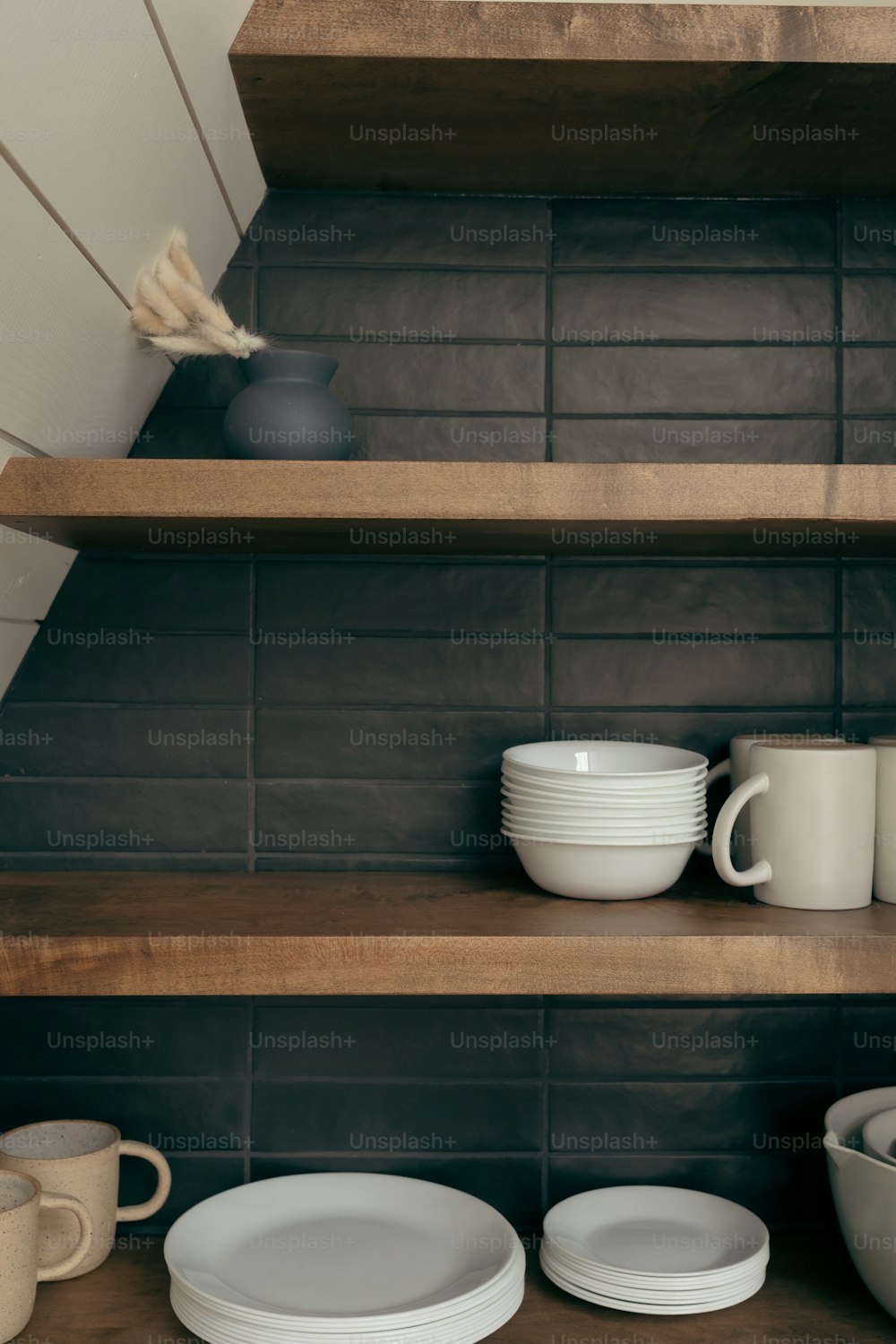 a shelf filled with plates and cups on top of wooden shelves
