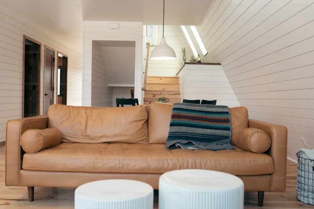 Un sofá de cuero marrón sentado en una sala de estar