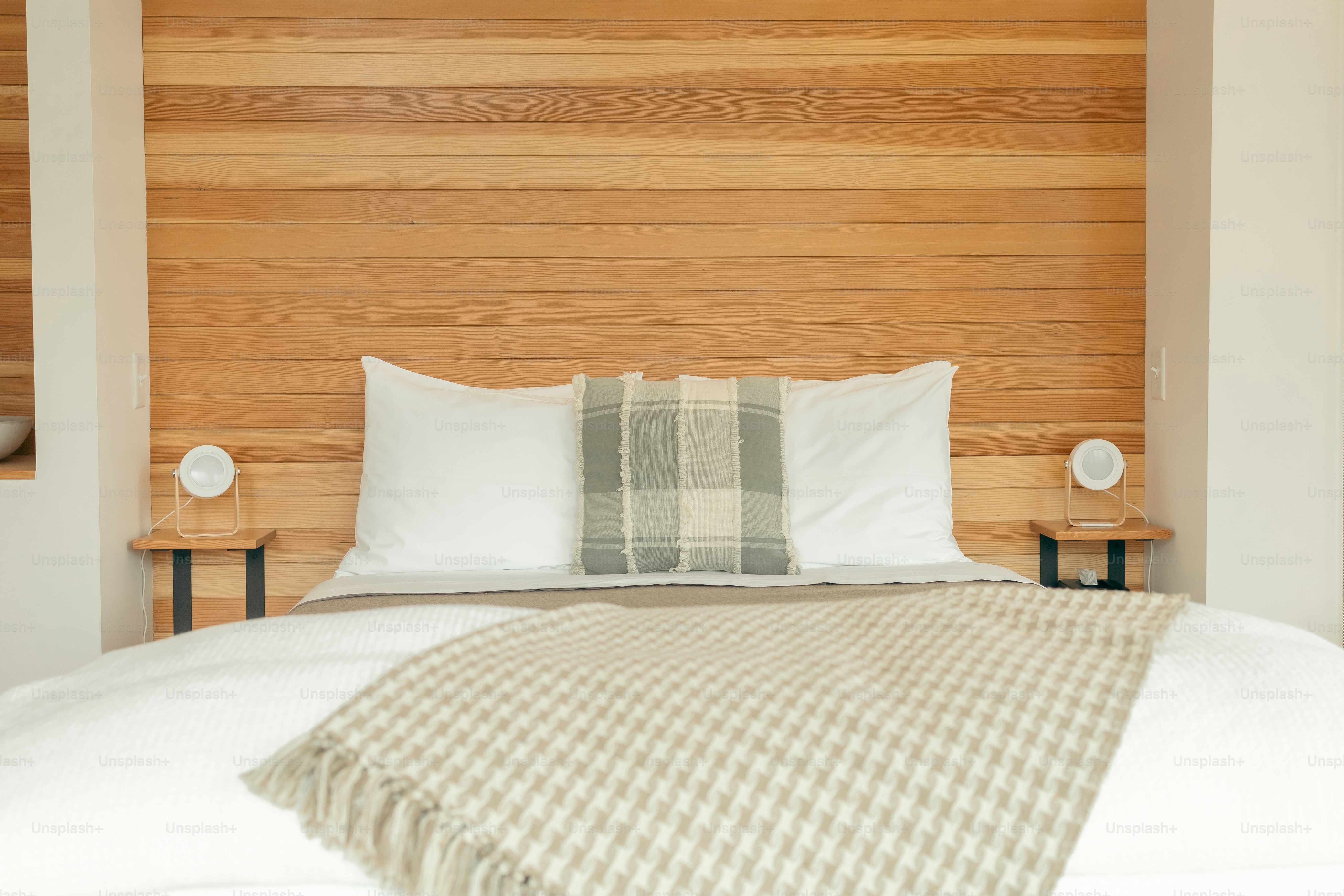 un lit avec deux oreillers et une couverture par-dessus