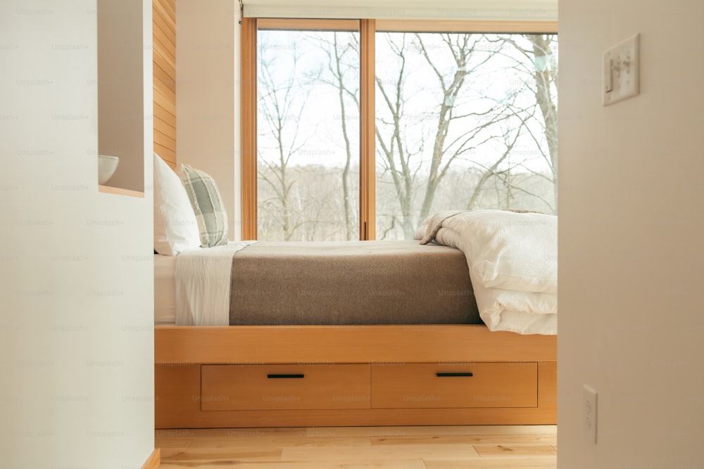 un letto seduto in una camera da letto accanto a una finestra