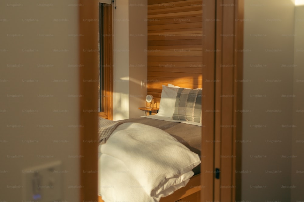 uma cama sentada em um quarto ao lado de uma porta de madeira