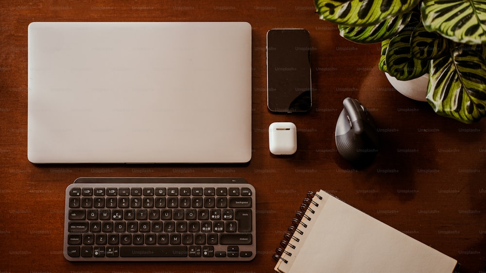 uma mesa com teclado, mouse e laptop