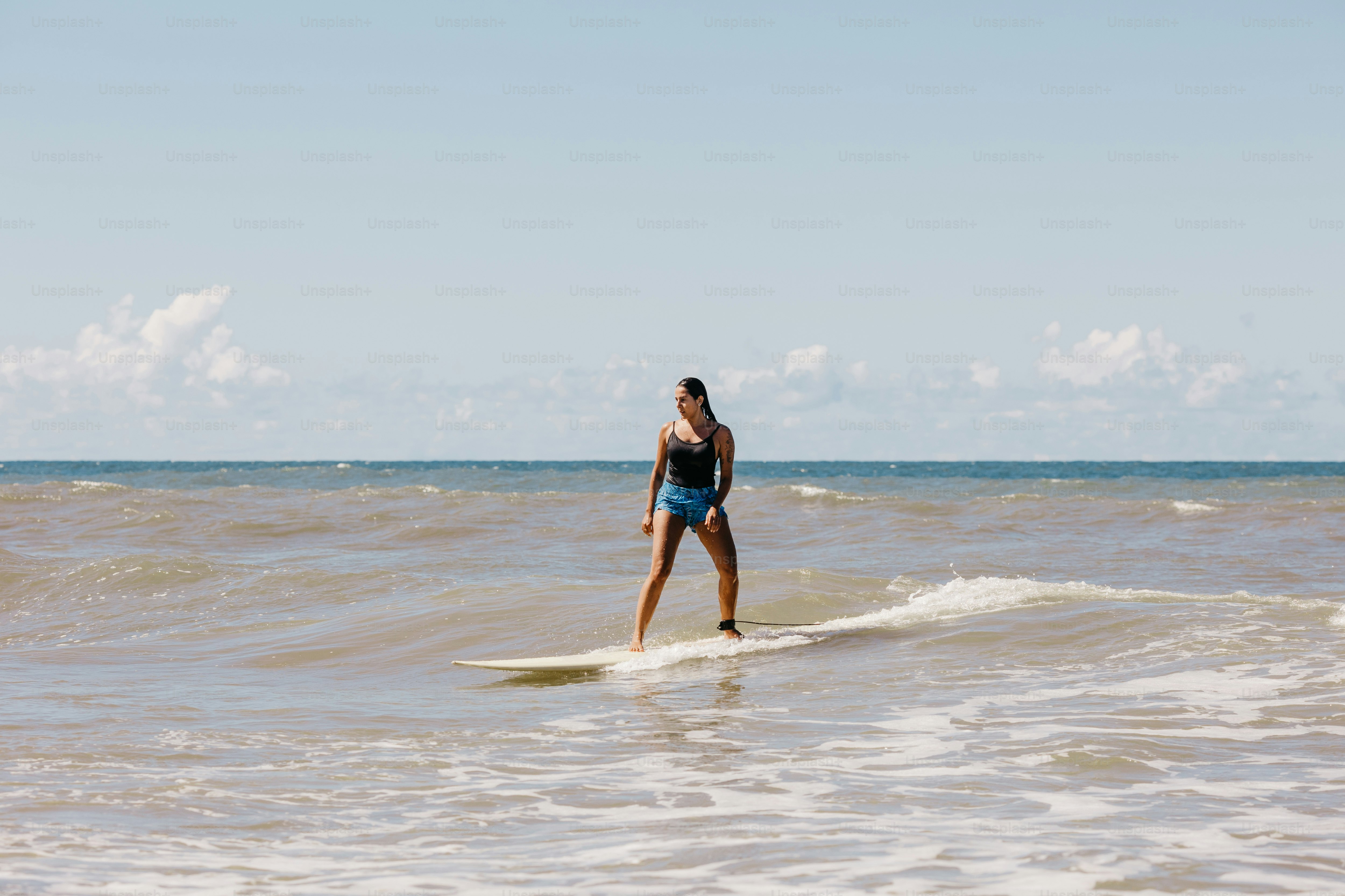 A woman riding a wave on top of a surfboard photo – Water Image on Unsplash