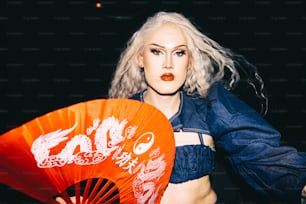 a woman with white hair holding an orange fan