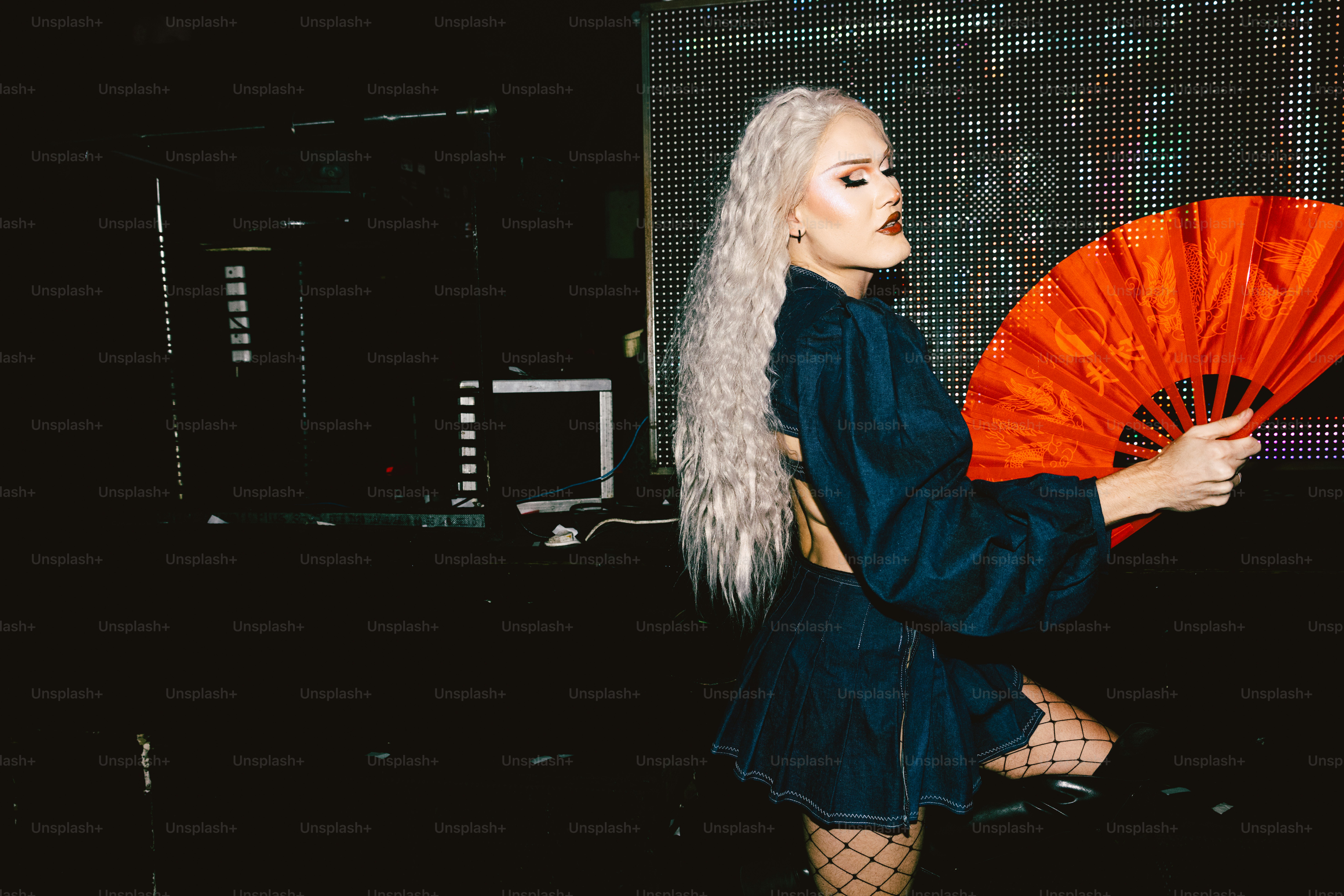 a woman with white hair holding a red fan