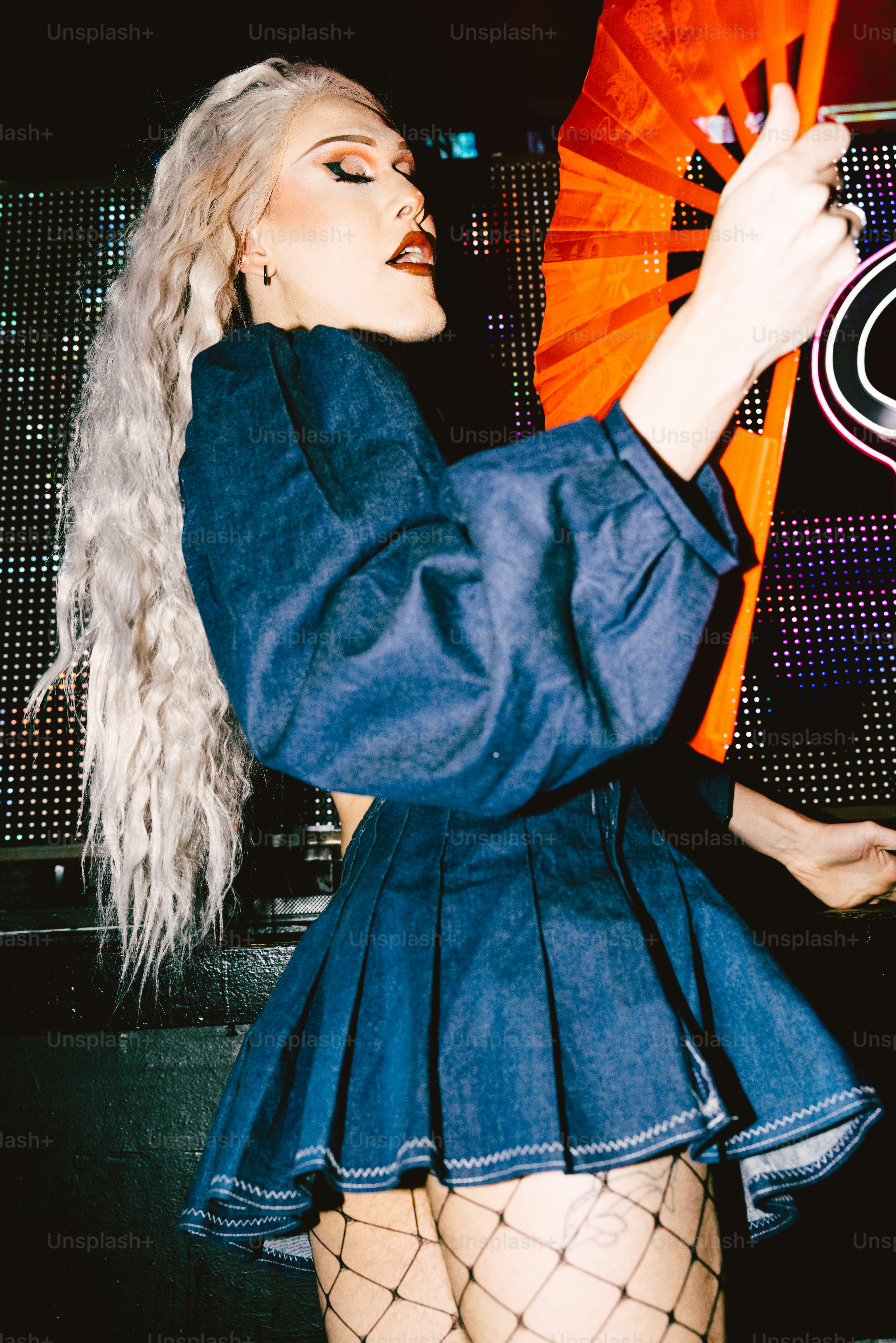 a woman in fishnet stockings holding a fan