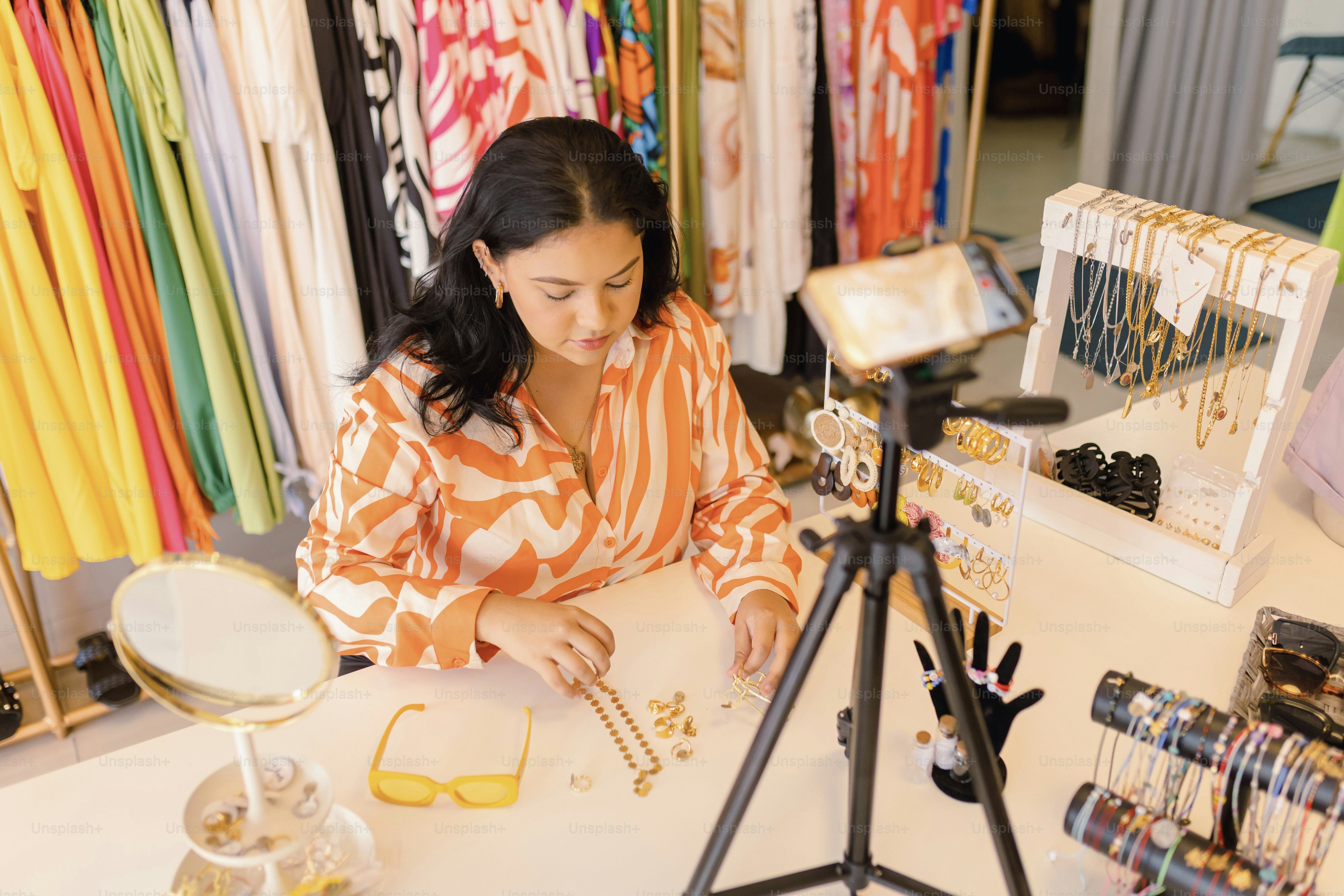 a woman sitting at a table in front of a camera