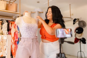 a woman standing in front of a dress on a mannequin