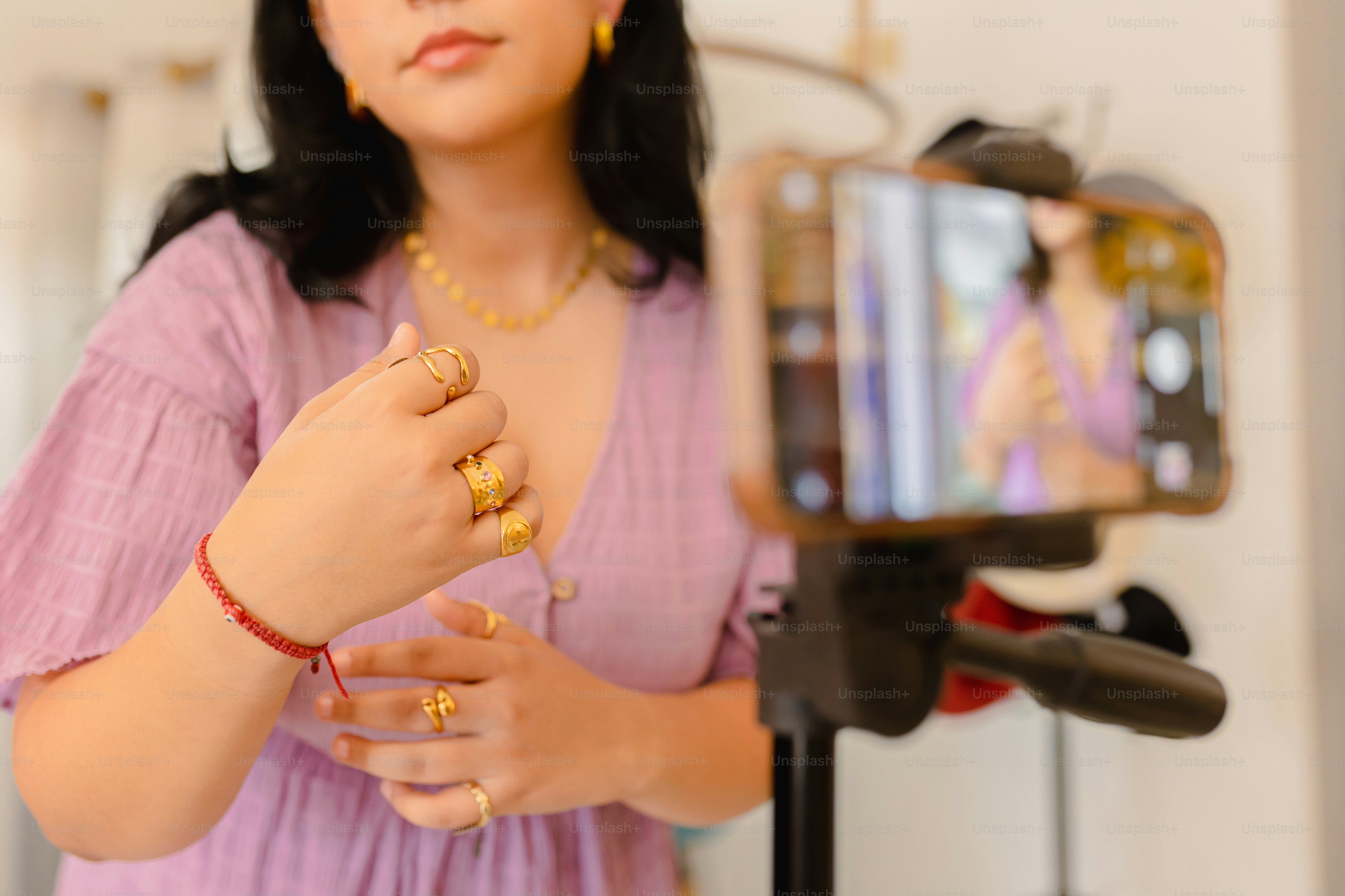a woman in a pink dress is holding a camera