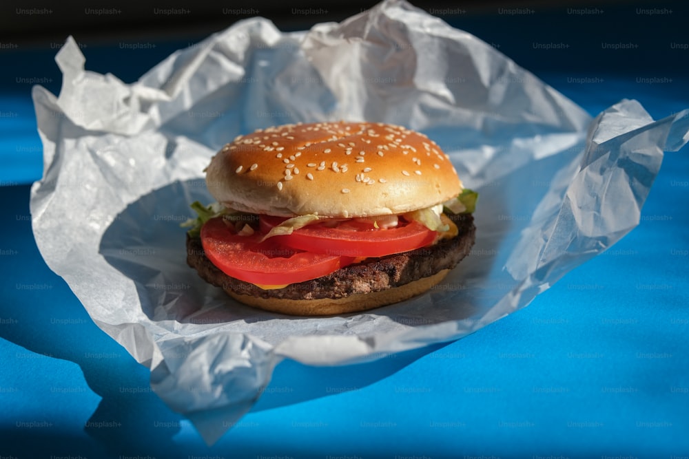 un hamburger con un pomodoro e lattuga su di esso