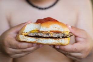 a person holding a hamburger in their hands