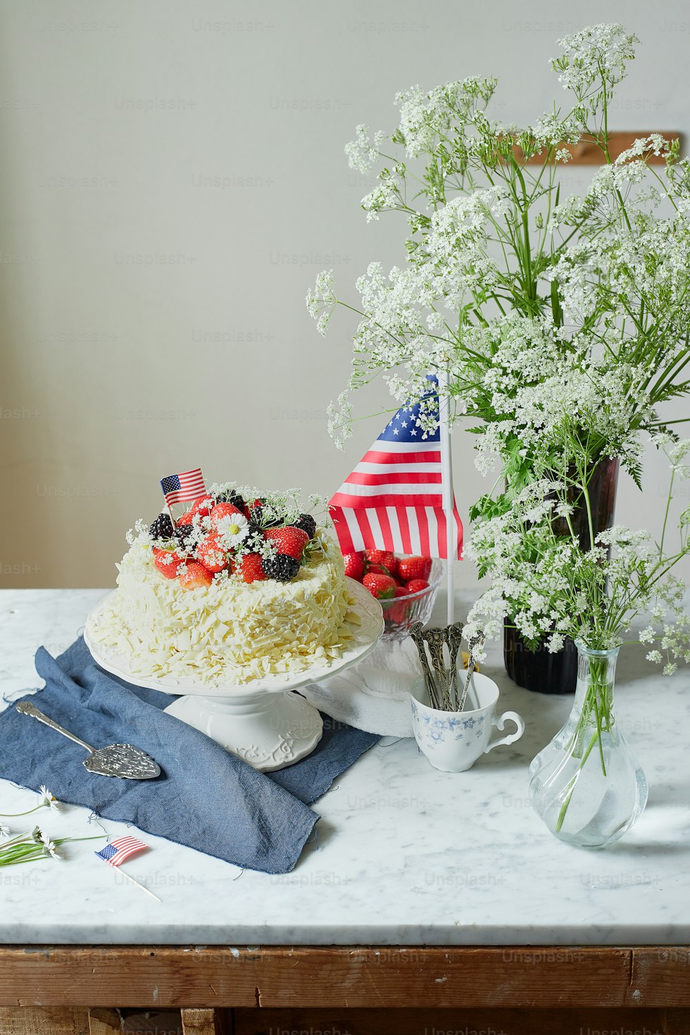 uma mesa coberta com um bolo e flores