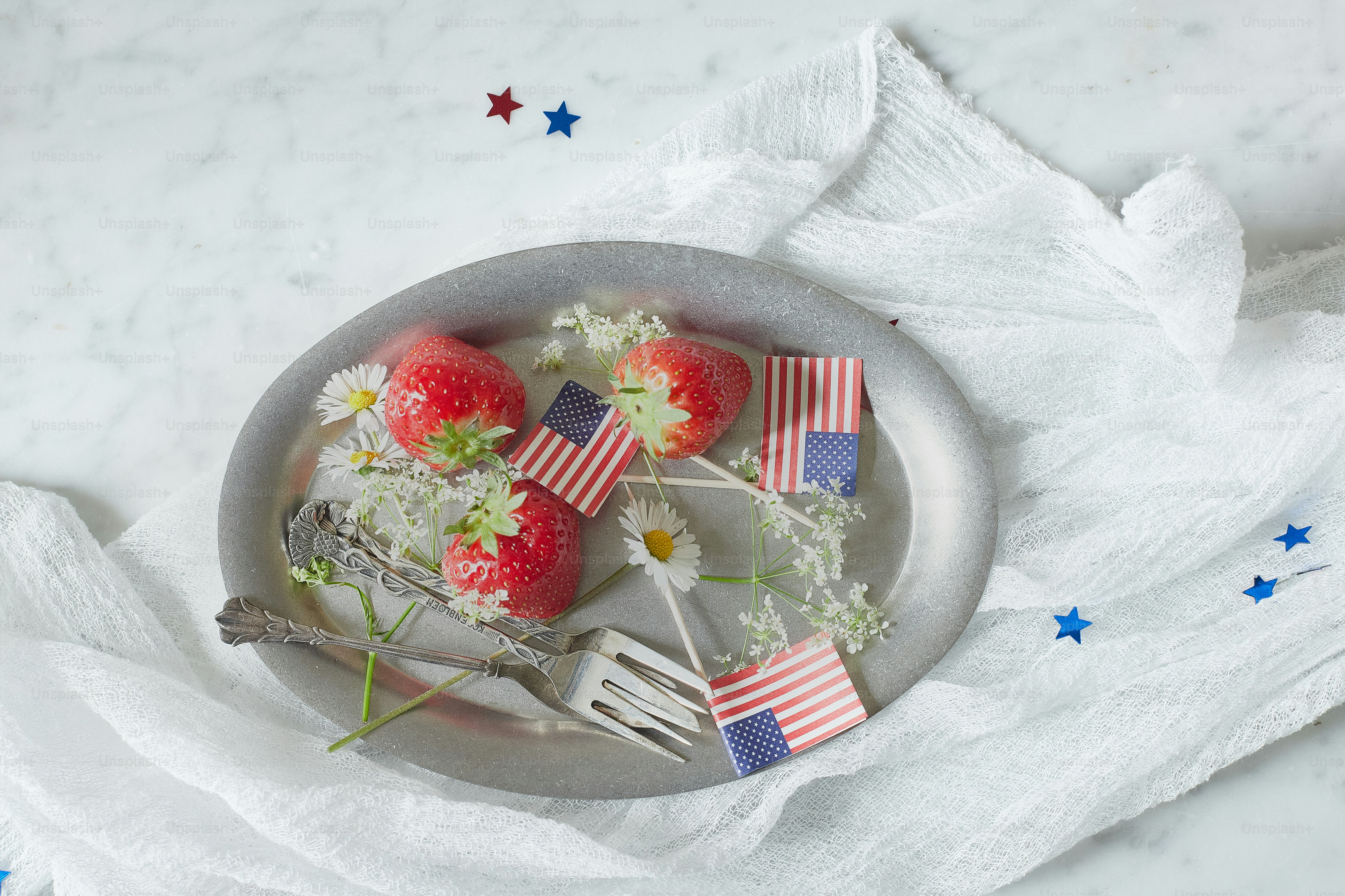a plate with strawberries and flowers on it