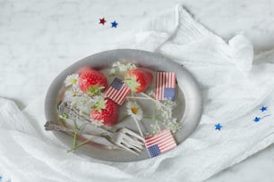 a plate with strawberries and flowers on it